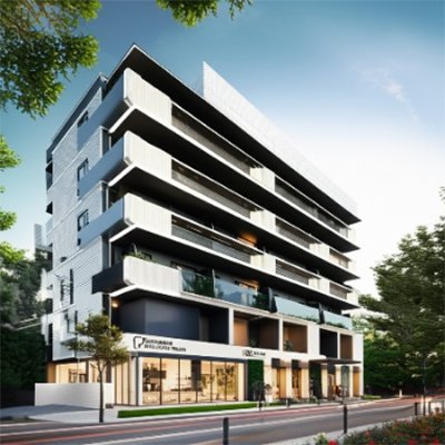 A striking, modern mixed-use building in Jaipur, completed by Anuda Architect, featuring a sleek design with multiple balconies, a combination of residential and street-level commercial spaces, and vibrant surroundings under a clear, sunny sky.